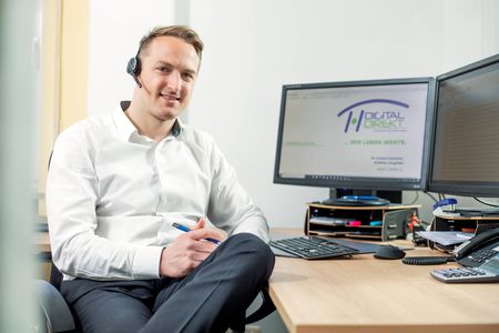 Vertriebsspezialist an Schreibtisch mit Headset - Digital Direkt - Regensburg